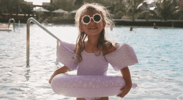 Niña_con_flotador_manguitos_y_bañador_leopardo_lila